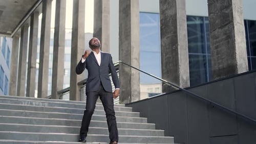 Triumphant Businessman Celebrates on Urban Staircase