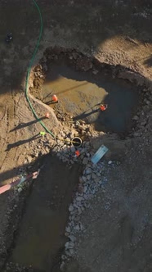 Vídeo vertical: Preparación de cimientos en una animada obra de construcción con mano de obra calificada