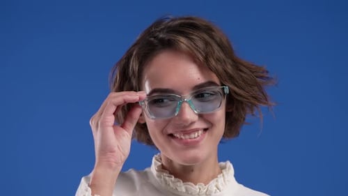 Portrait of Cute Funny Woman in Blue Sunglasses on Studio Background