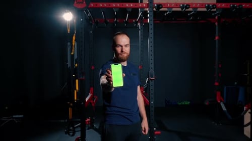 man fitness trainer shows phone with green screen sport lifestyle training technology