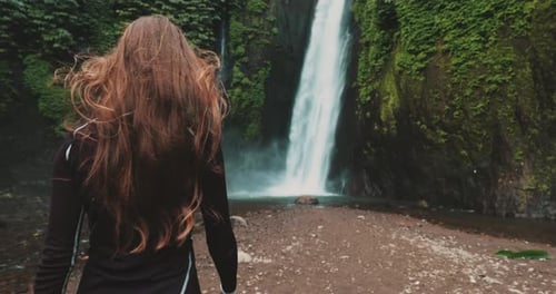 Young Woman Enjoying Waterfall in Tropical Jungle Forest