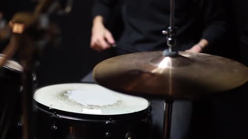 Musician playing drums in a dark room