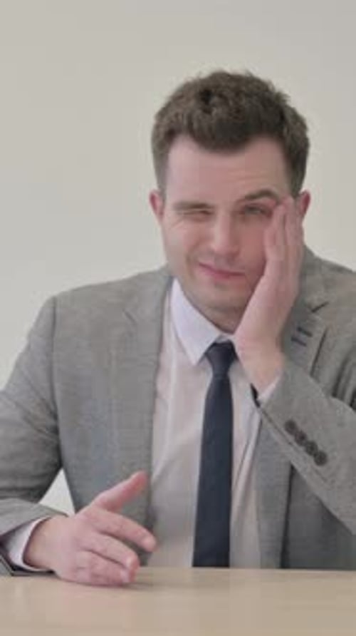 Young Man with Headache in Gray Suit