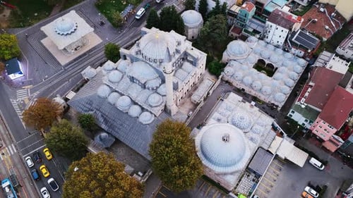 Mosque complex with multiple domes and a minaret seen from above, highlighting traditional Islamic