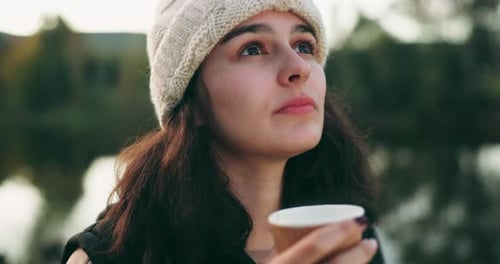 Woman Contemplating Outdoors with Hot Drink