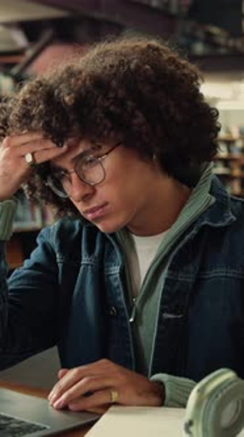 Library, laptop and student with headache, stress or fatigue with education pressure in college