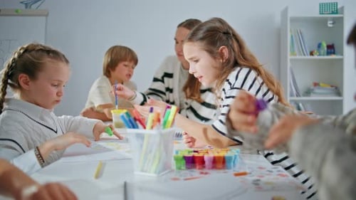 Active Pupils Art Lesson in School closeupTeacher Explaining Task Helping Boy