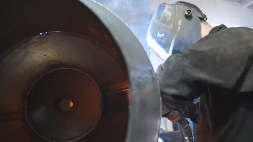 Arbeiter im Bereich Schutzmaskenschweißen, Metallbau in einer metallverarbeitenden Fabrik, Schweißer macht Verbindung