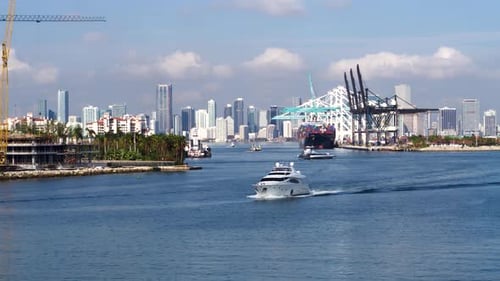 Yacht cruises away from the Miami harbor on a bright summer day in Florida
