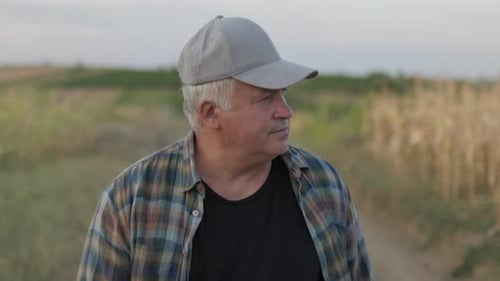Senior Man in Agricultural Field Walking Along Rural Pathway