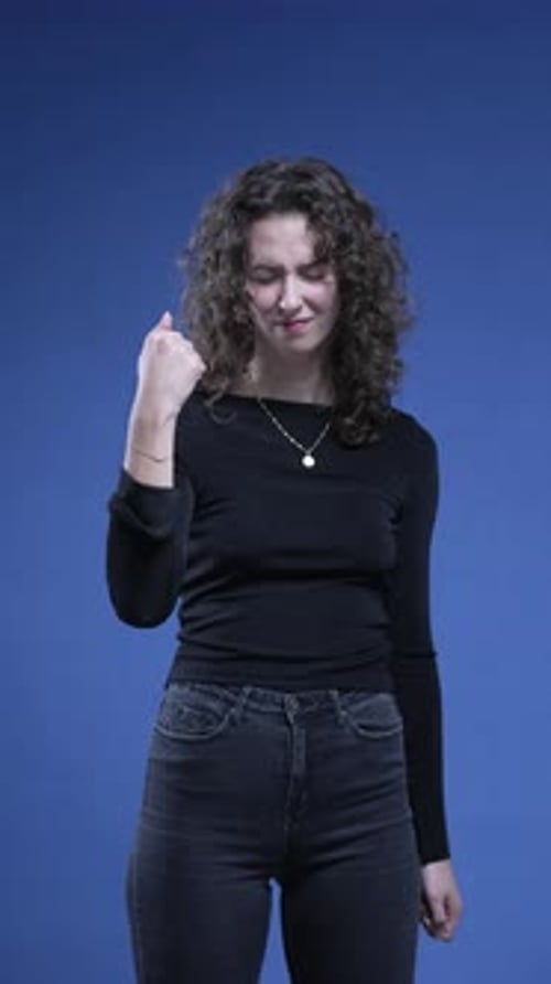 Woman celebrates succes by raising fist feeling excitement about achievement standing