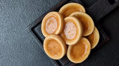 Round mini tartlets with citrus or peach jam and crumbly pastry. Mini citrus tarts