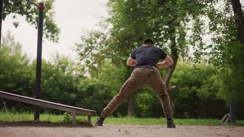 Man Warming Up Legs in Urban Park Area