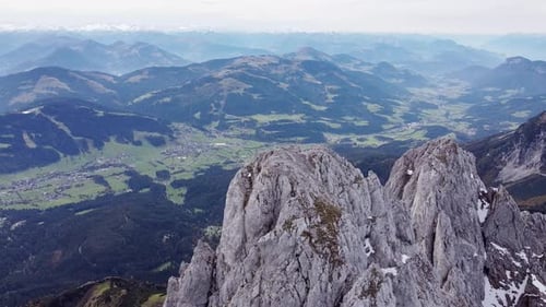 Aerial of steep rocky alpine mountain top peaks, epic landscape drone scenery view into valley and m