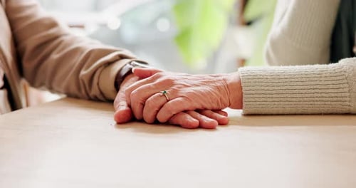 Holding hands, sympathy and senior couple by table for support, care or condolences for loss