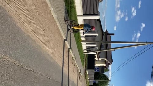 Vertical Video Boy in Protective Safe Bicycle Helmet Rides Bicycle on Road