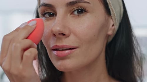 Woman Applying Makeup with Sponge Applicator, Close-Up Beauty Shot