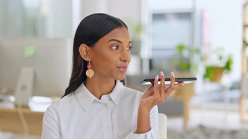 Young Woman Recording Voice Message in Office