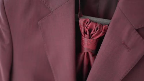 Close up of elegant burgundy suit with matching cravat