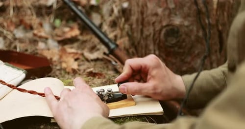 Person Operates Morse Code Machine Next to Rifle