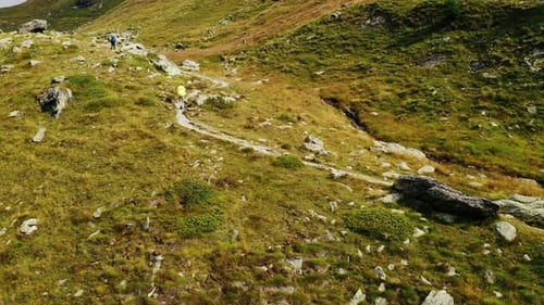 Hikers Trekking Scenic Mountain Trail on Sunny Day