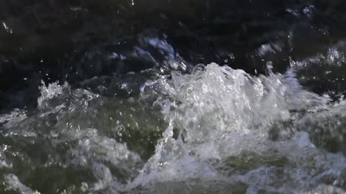 Close-up of wild foaming and rolling water. Slow motion shot.