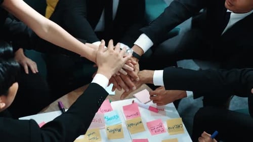 Top view of people putting hands together while using task board. Directorate.