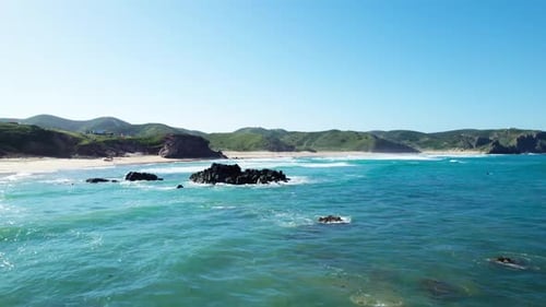 Flying Over The Blue Sea With Rocks And Breaking Waves. - aerial shot