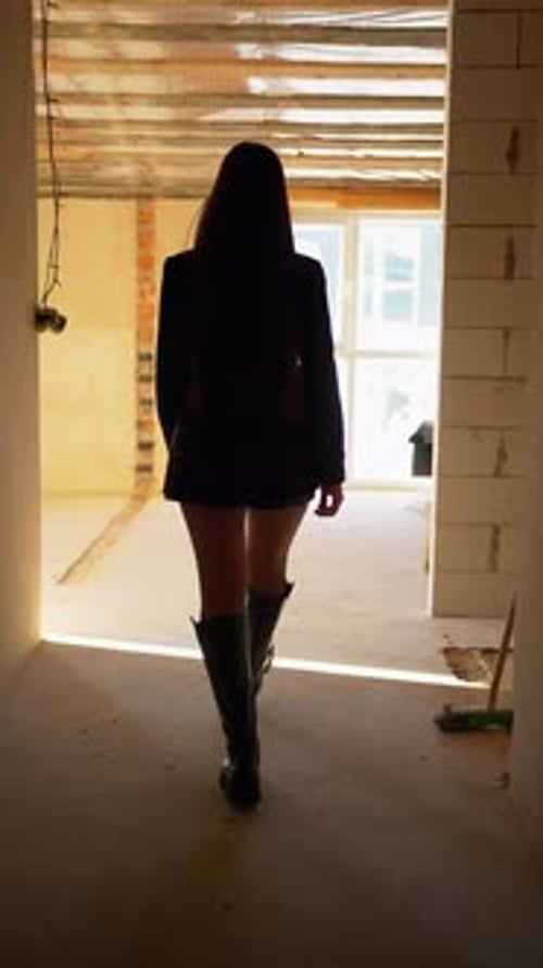 Woman in Jacket and Boots Walking Indoors