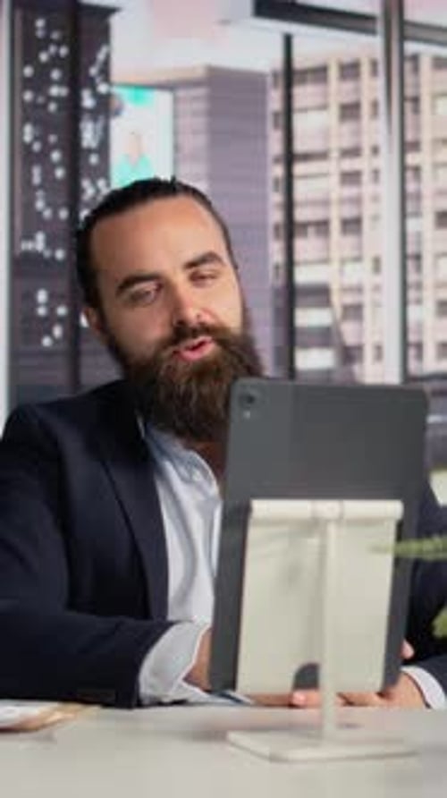 Bearded Man Video Conferencing in Modern Office Setting