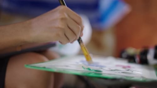Woman Painting Flower Design on White Shoe