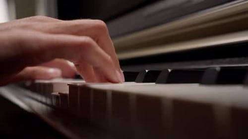 Close-up of a woman's hands in silver rings playing beautiful lyrical melody on the piano keys