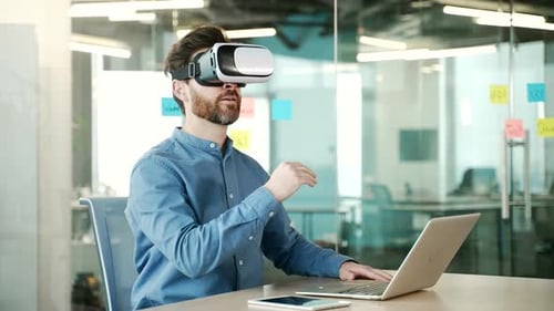 Confident entrepreneur works using VR glasses in virtual reality simulator sitting at workplace