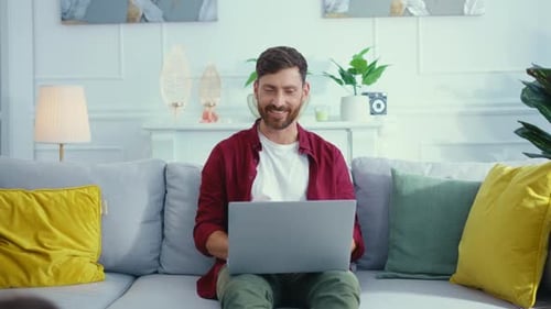 Family Enjoys Laptop Together on Couch in Bright Home