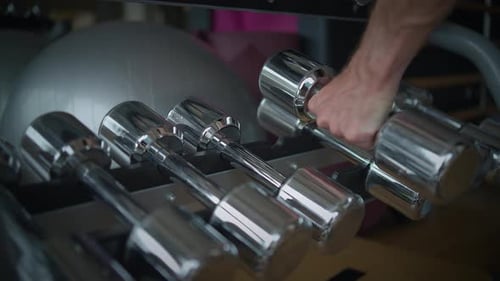 A CloseUp View of Shiny Metallic Dumbbells in a Contemporary and Modern Gym Setting