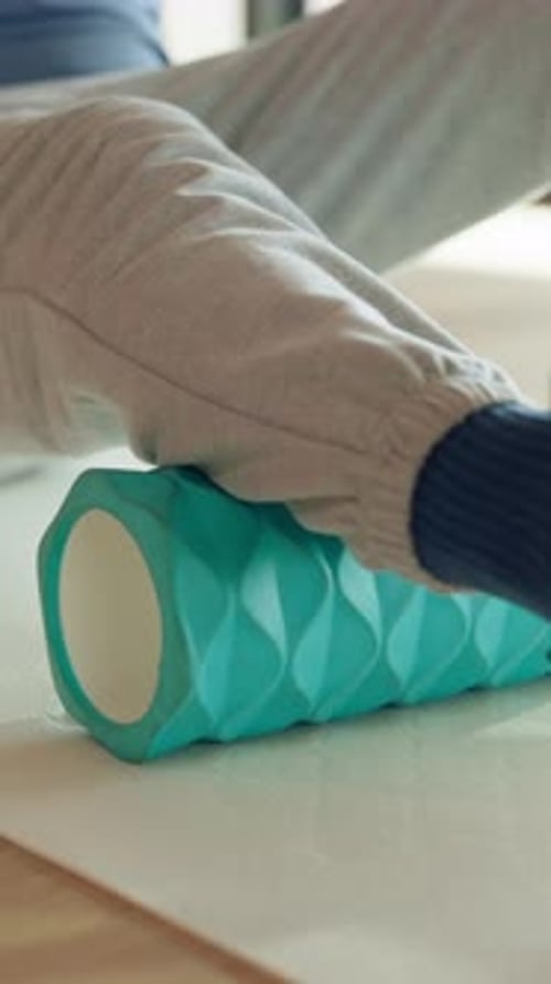 Adult using a foam roller on calf muscle