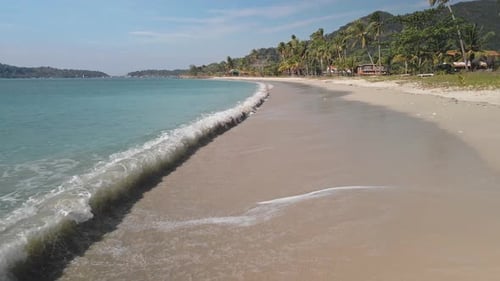 Drohne fängt Meereswellen am leeren weißen Sandstrand ein, Meereswelle reist zum Küstenstrand