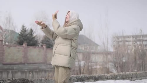 Woman in Winter Coat Puts on Gloves Outdoors