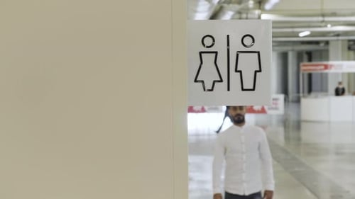 Young man walking inside the public bathroom inside shopping mall