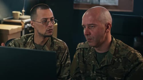 Officers Analyzing Information on Laptop in Command Center