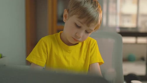 Kleiner Junge macht Hausaufgaben an seinem Schreibtisch