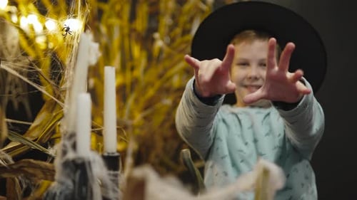 Smiling Child in Witch Hat Poses for Halloween