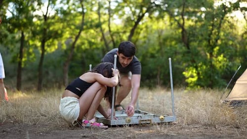 People Camping and Assembling a Table in the Forest