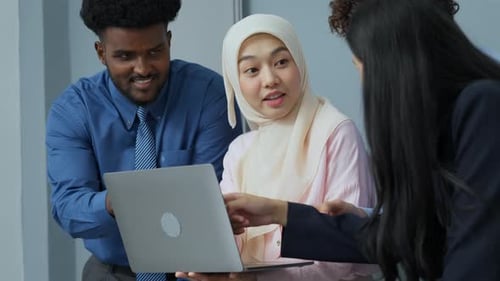 Business team collaborates on laptop in office