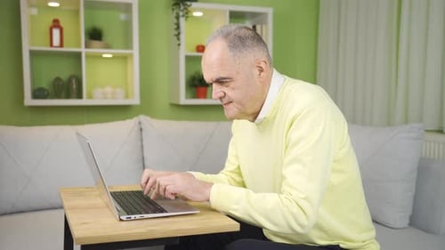 Mature Adult Typing on Laptop Indoors