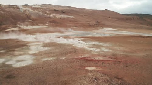 Flying Above Steaming Geothermal Area Of Hverir Near Lake Myvatn In North Iceland. low aerial