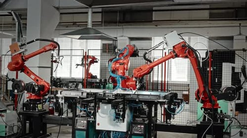 Automated Robotic Arms Welding Metal in a Factory
