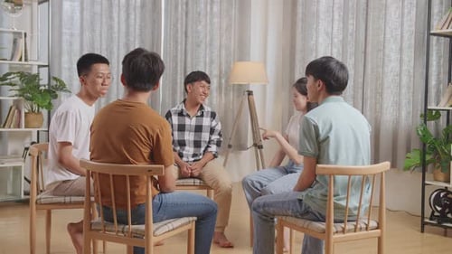 Asian Teen Group Sitting In Chairs Forming A Circle Discussing At Home