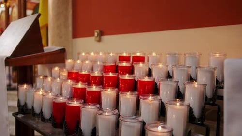 Burning Candles in Glass Holders Inside a Church