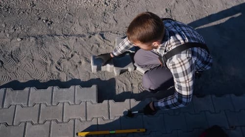 Man laying paving stones in outdoor construction